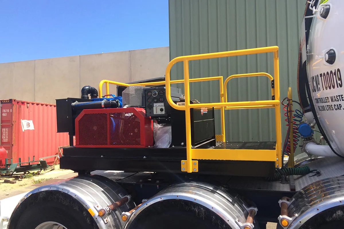 Yellow safety railing and platform fabricated on a waste truck