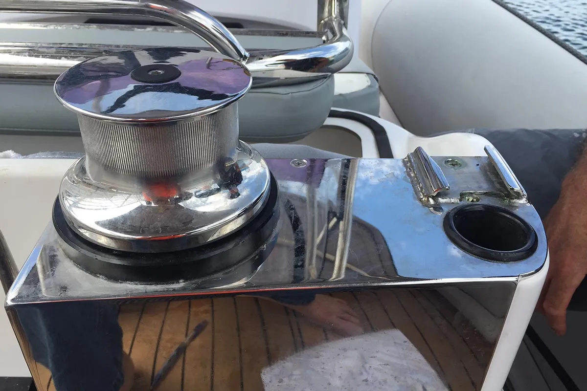 Polished stainless steel boat fitting with a winch and cup holder
