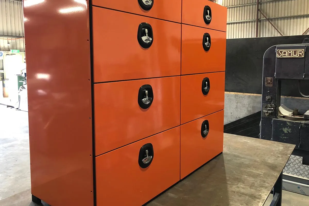 Orange powder-coated steel locker cabinet in the workshop